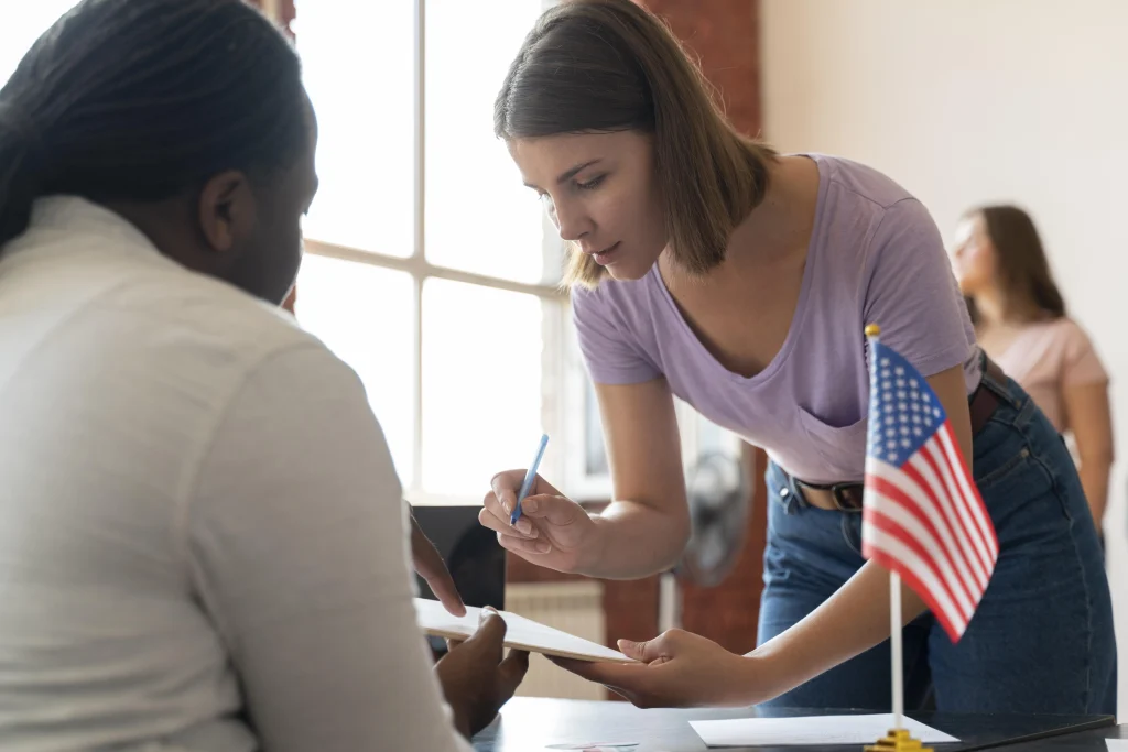 Jeune femme signant un document administratif devant un drapeau américain, symbolisant les démarches officielles aux États-Unis.