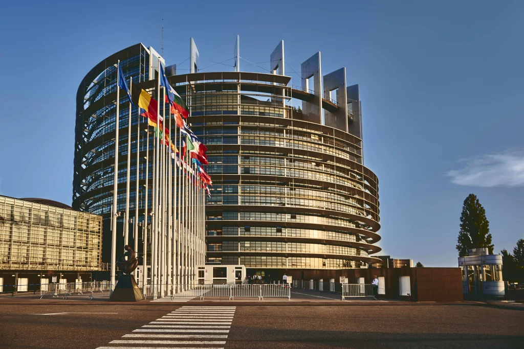 Bâtiment moderne avec drapeaux européens devant le consulat, illustration des démarches administratives pour un visa pour le Brésil