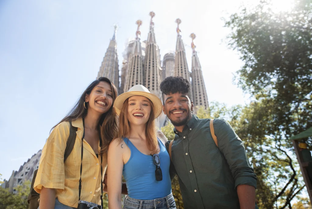 Jeunes expatriés souriants profitant d’un séjour à Barcelone, devant la Sagrada Família.
