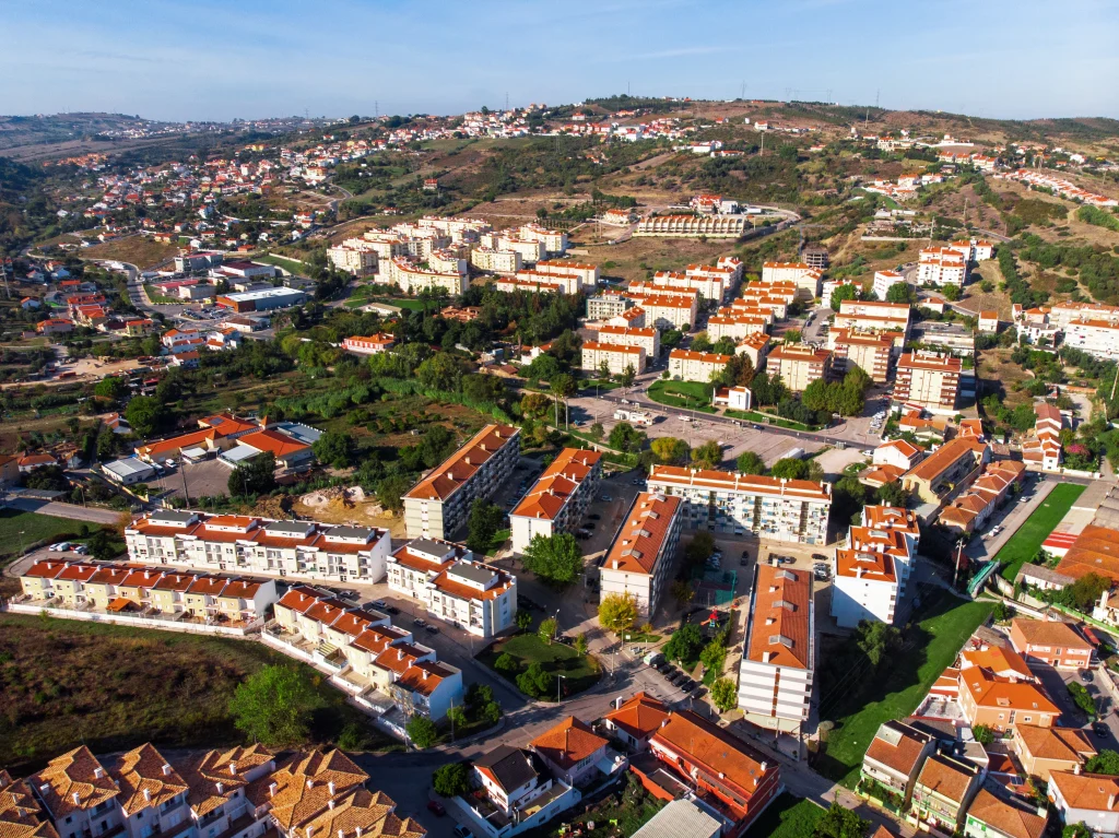 Vue aérienne d’un quartier résidentiel au Portugal avec maisons rouges et collines — immobilier au Portugal