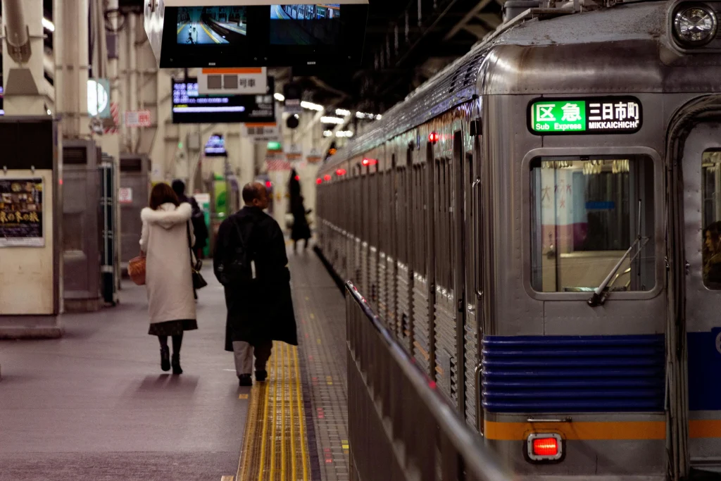 Gens attendant sur un quai de métro au Japon avec un train express prêt à partir