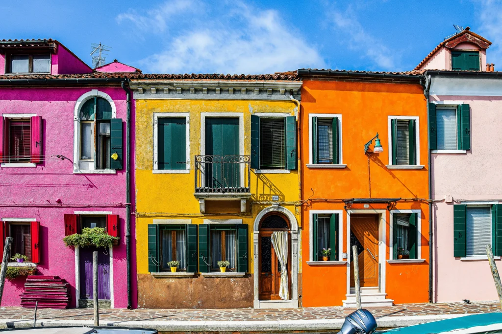 Colorful homes in Burano showcasing the charm of buying a property in Italy for holiday rentals.