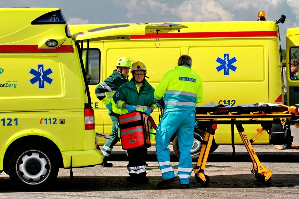 Dutch healthcare system emergency services, featuring paramedics and a yellow ambulance responding to a medical situation.