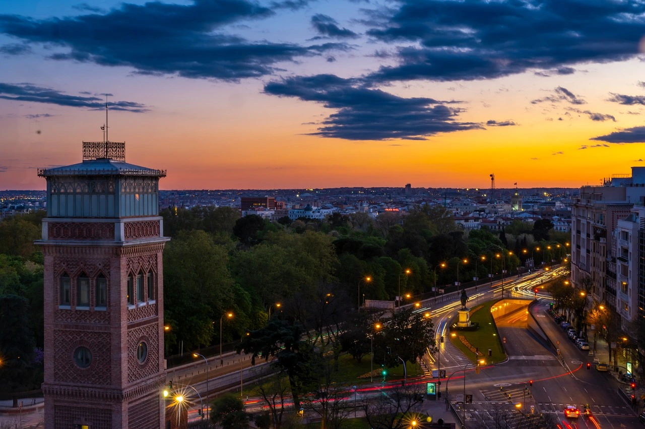 A stunning sunset over Madrid, showcasing city lights and historic architecture. Discover why Madrid is one of the best cities in Spain to live and visit.
