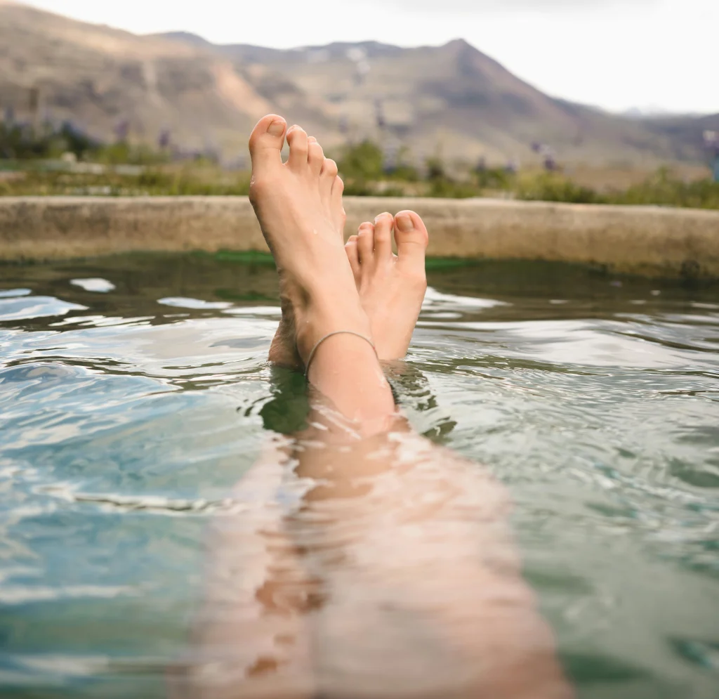 Que faire au Japon-expatis-Personne dans un onsen avec les pieds croisés en train de profiter de la vue sur des montagnes. 