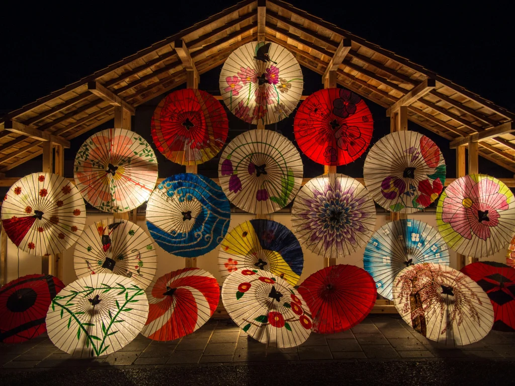 affichage de wagasa, les ombrelles traditionnelles japonaises en papier huilé pour un festival
Elles sont exposées sous une structure en bois avec un toit.