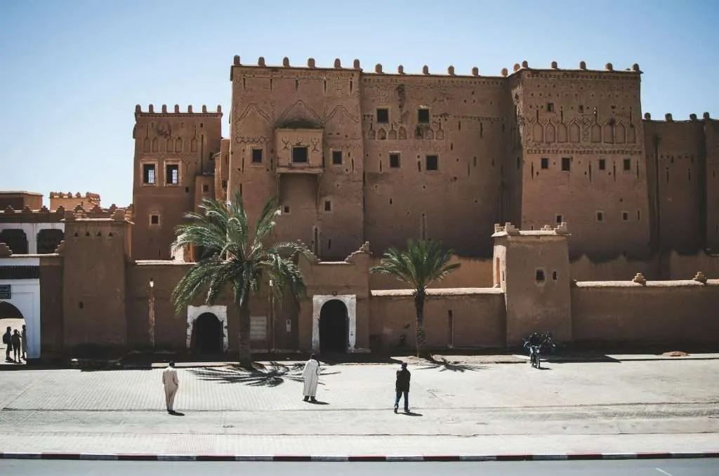 Traditional Moroccan kasbah with palm trees in Ouarzazate, symbolizing cultural heritage and cost of living in southern Morocco