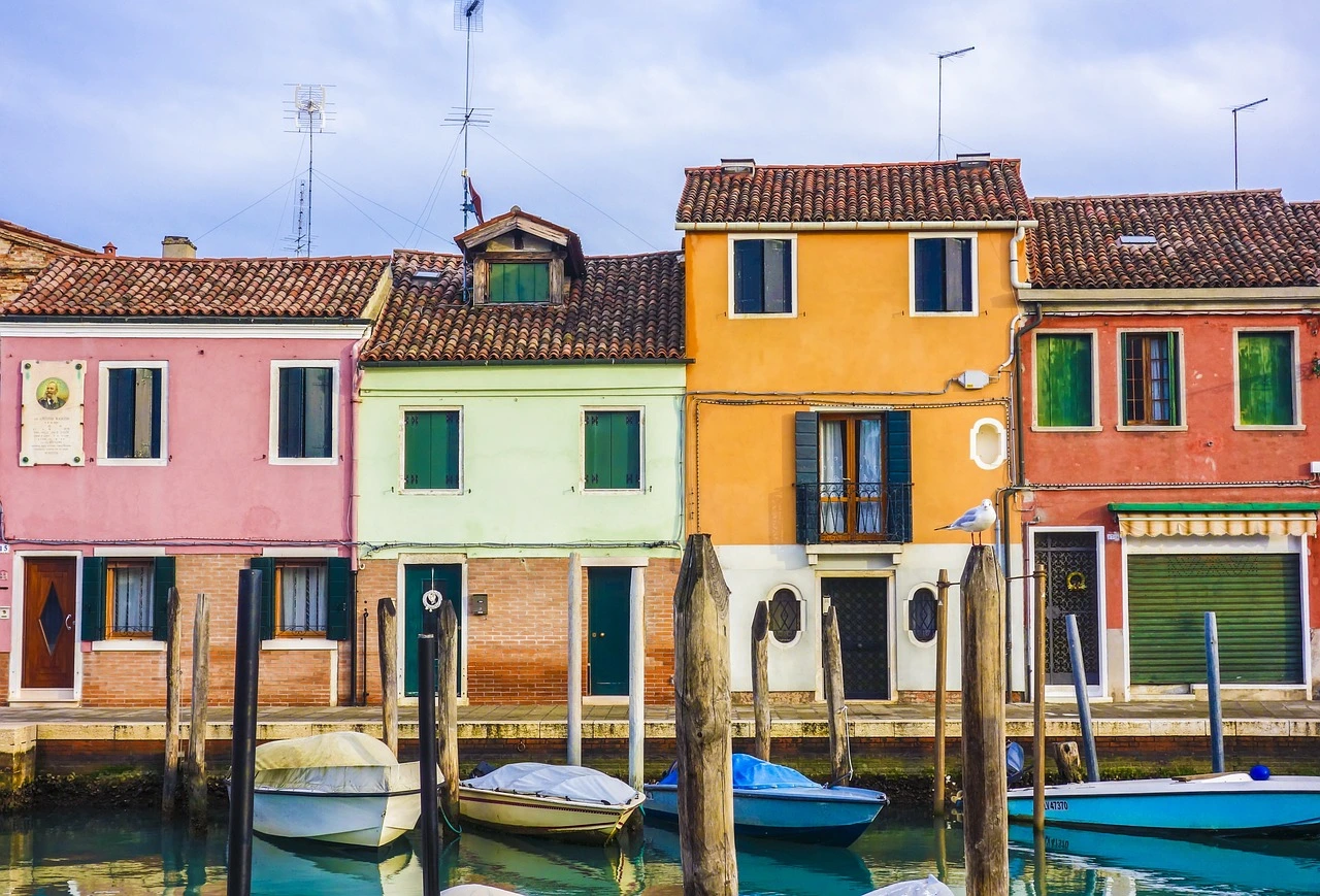 Picturesque canal-side homes in Burano, Venice, showcasing the unique architecture and vibrant charm that attract many to buying property in Italy.