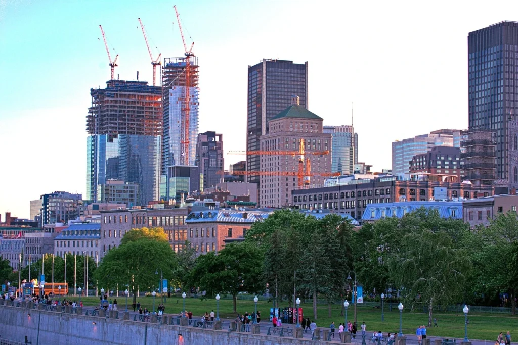 Montréal skyline at dusk with historic and modern architecture, green parks, and bustling streets, capturing the city’s dynamic urban and cultural atmosphere.