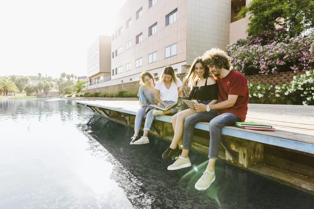 Des étudiants étudiant au bord de l'eau dans une université aux Pays-Bas, profitant d'un environnement académique dynamique et international.