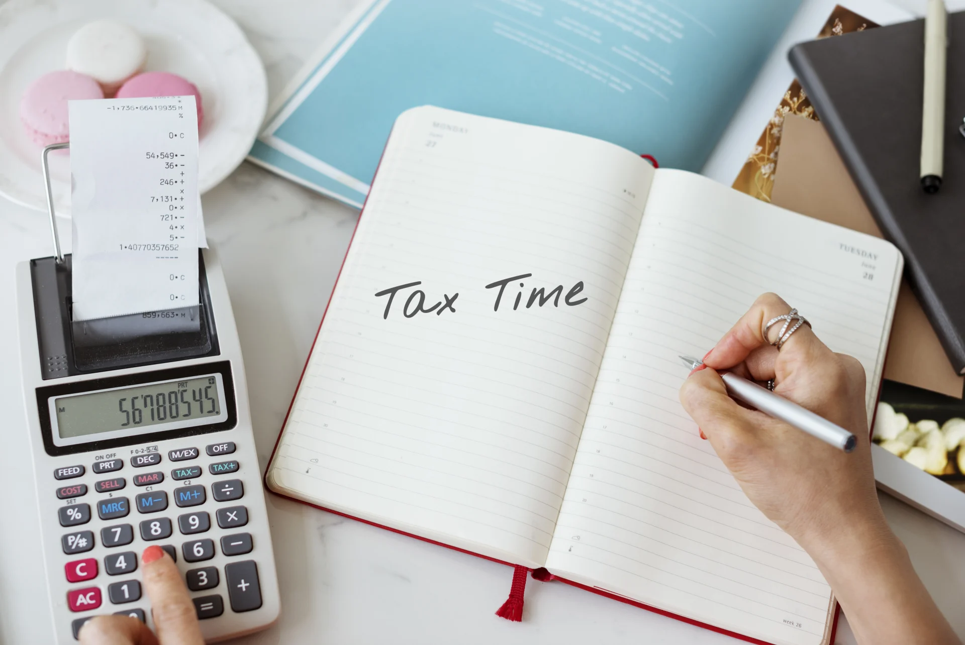 Notebook with 'Tax Time' written beside calculator and receipt, illustrating tax filing and deadlines related to Taxes in China.