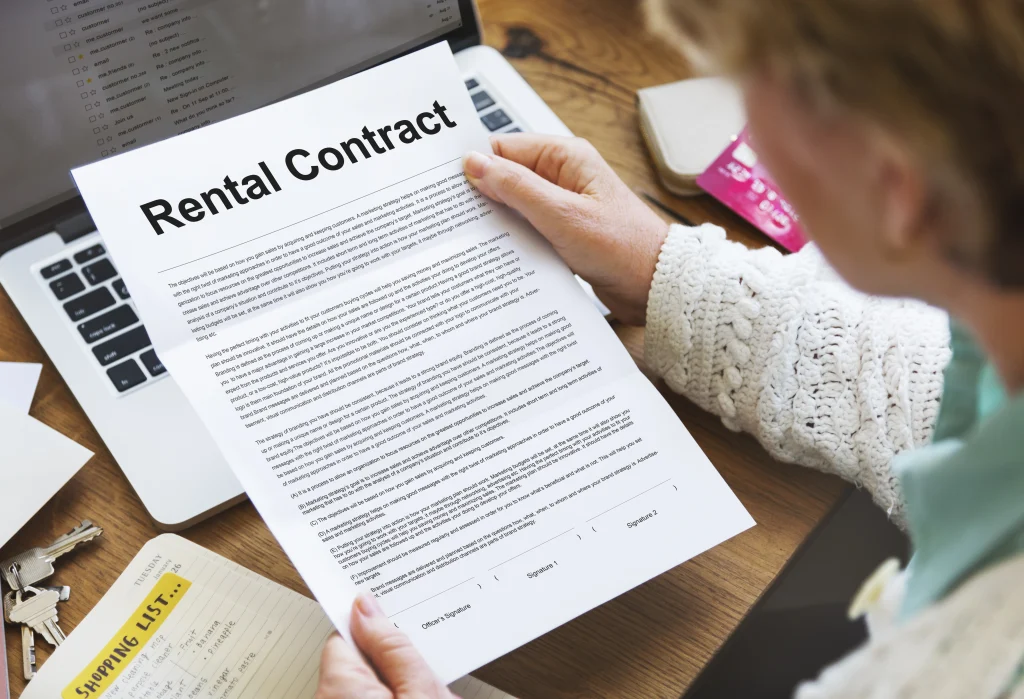 Personne lisant un contrat de logement au Canada, mettant en avant les démarches administratives et les accords de bail.