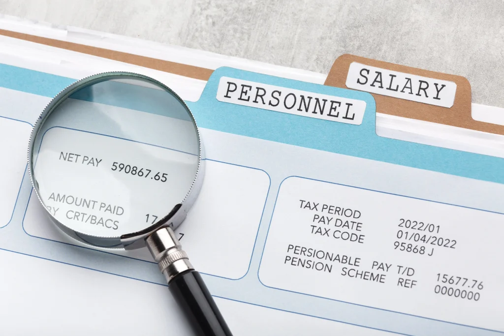 Salary statement and personnel file under review, representing income checks and benefits linked to Unemployment in Italy.