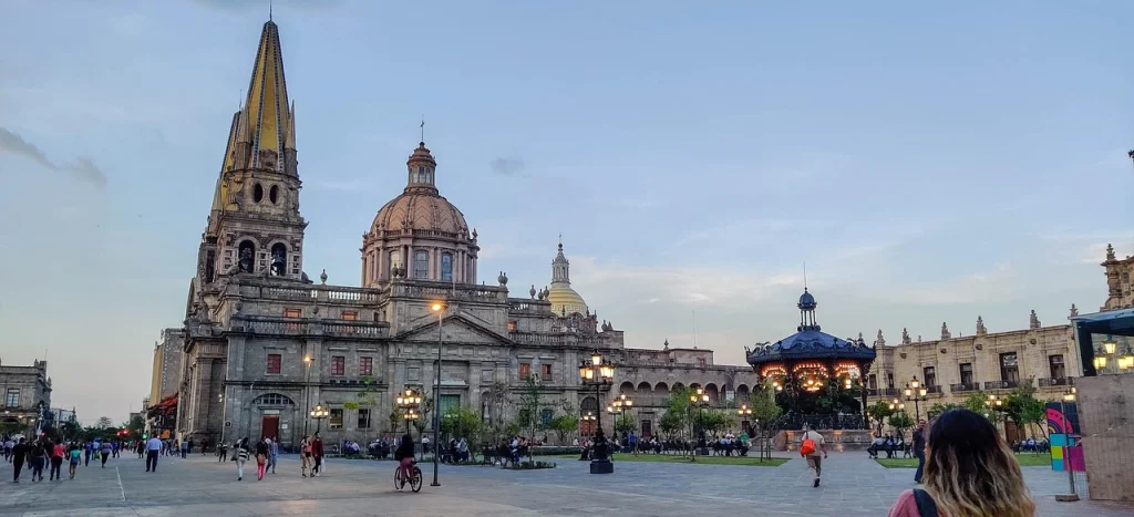 Vue impressionnante de la cathédrale de Guadalajara et de la place publique animée en soirée.