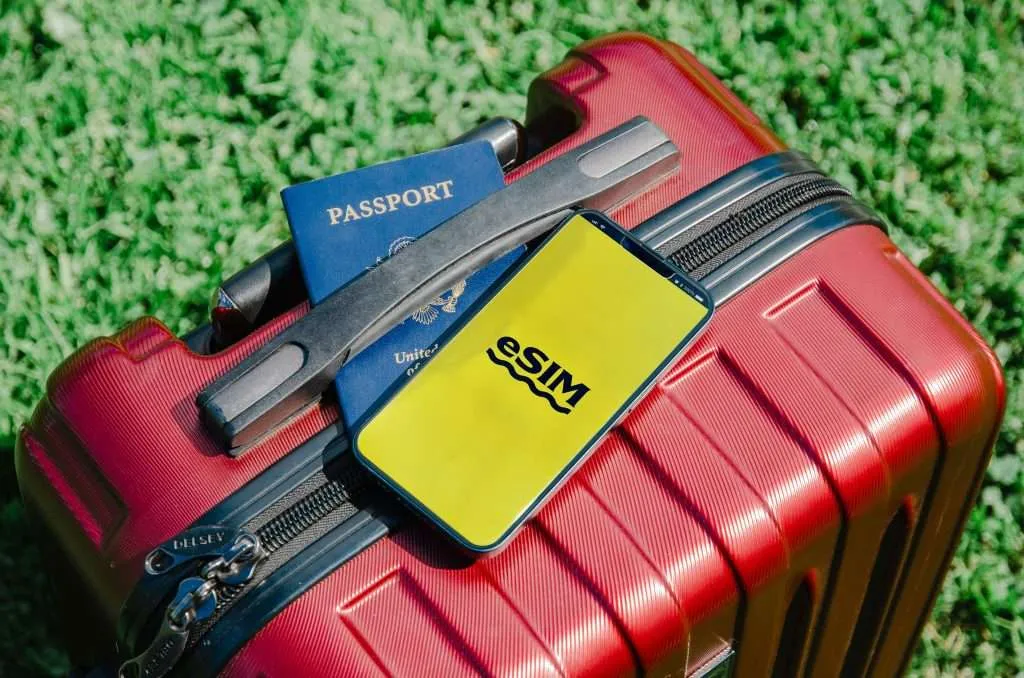 eSIM for Thailand displayed with a suitcase, passport and an iPhone. 