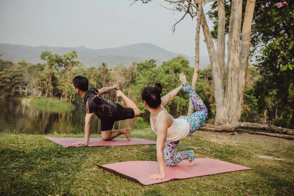 Couple pratiquant le yoga en plein air à Bali, représentant le mode de vie axé sur le bien-être et son influence sur le coût de la vie à Bali.