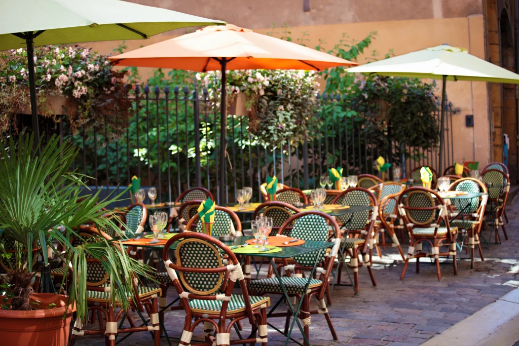 Restaurant en plein air à Malte avec des parasols et des chaises colorés, reflétant le style de vie local et le coût de la vie à Malte pour les repas à l'extérieur.