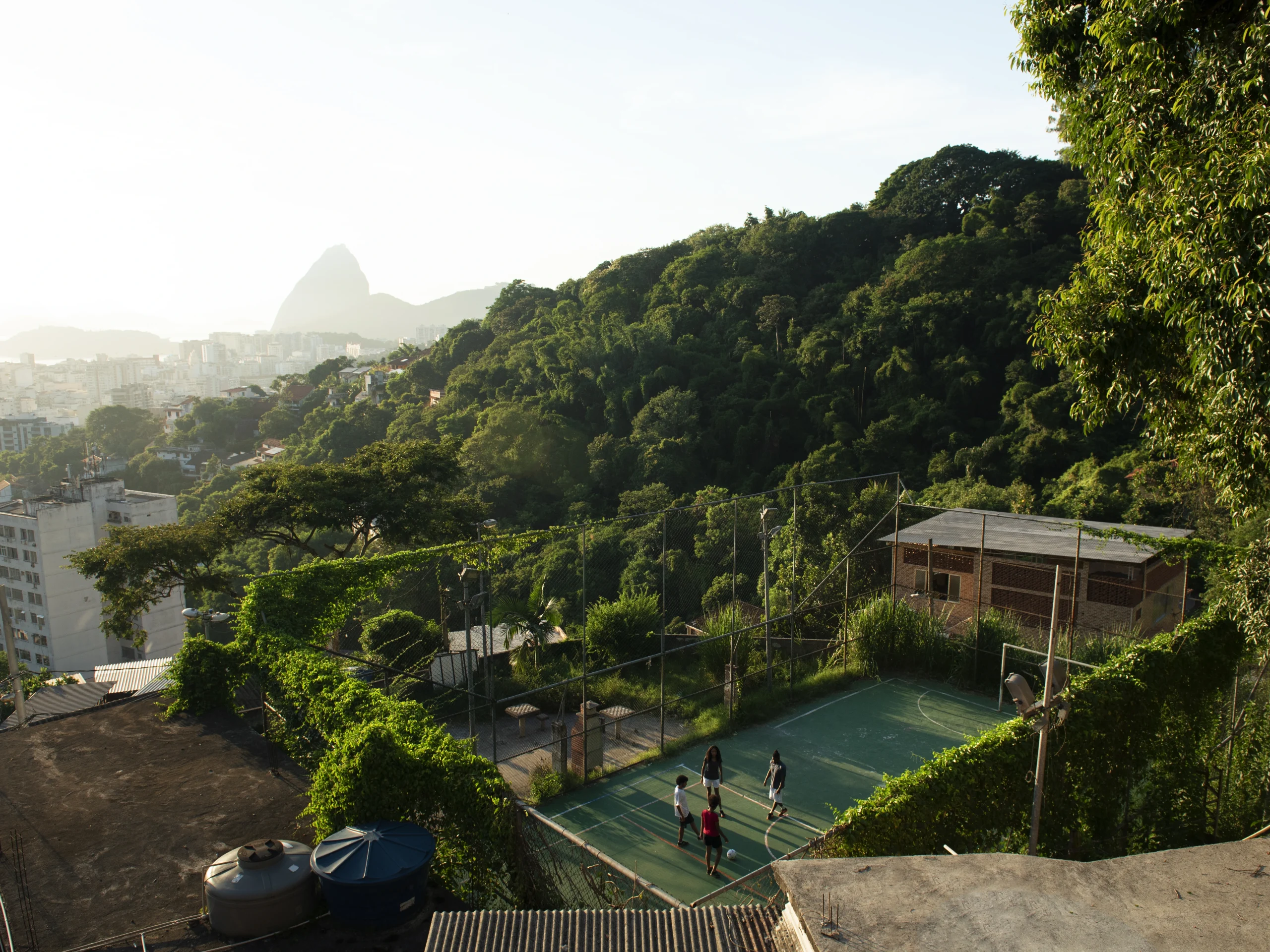 Children play on a hillside court above a lush cityscape, a scene as connected and dynamic as life with Internet in Bali.