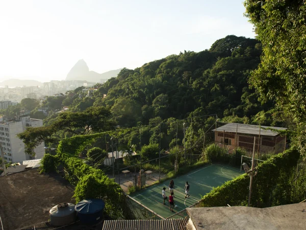 Children play on a hillside court above a lush cityscape, a scene as connected and dynamic as life with Internet in Bali.