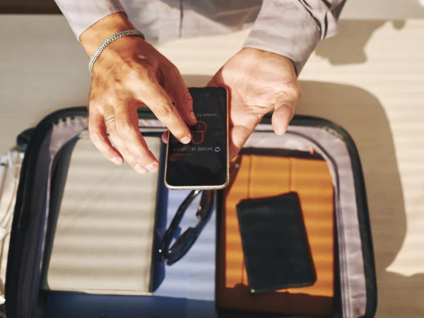 Personne saisissant les informations de la TDAC sur un ordinateur portable avec un passeport et des documents de voyage à proximité.