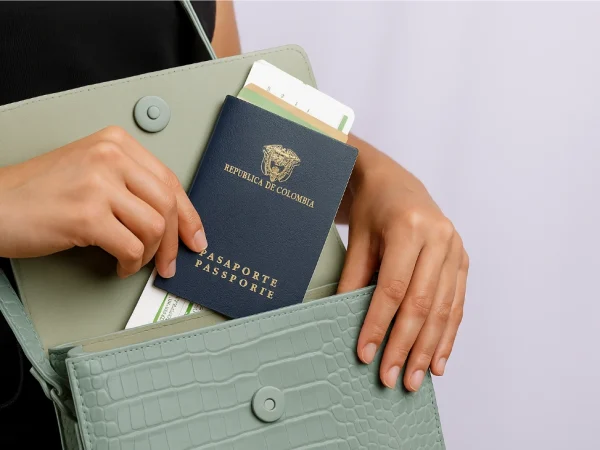 Close-up of a Colombian passport being placed in a handbag, representing the Visa in Colombia process for travel or relocation