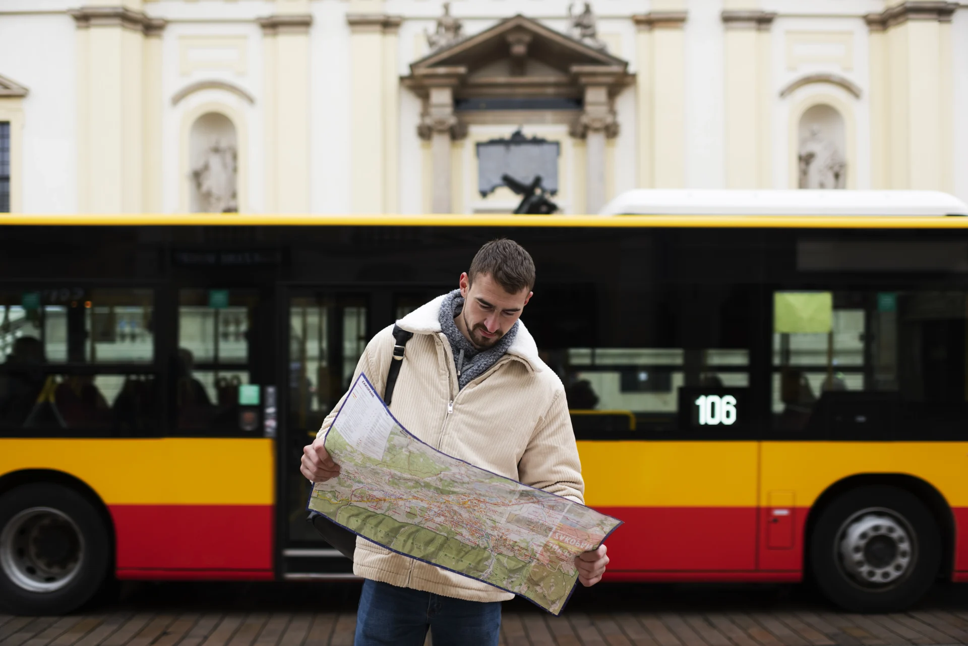 Man checking a map near a local bus, reflecting transportation choices and how public transit impacts the cost of living in Colombia.