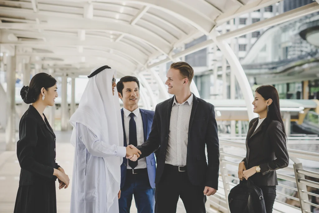 Qatari businessman shaking hands with international businessman. Symbolising job contracts in Dubai.