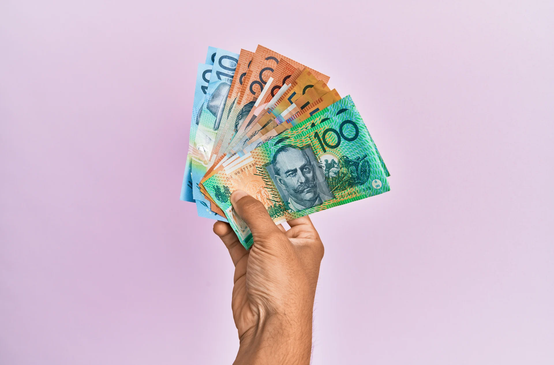 Main tenant des billets australiens, illustrant les dépenses personnelles et le coût de la vie en Australie en 2025.