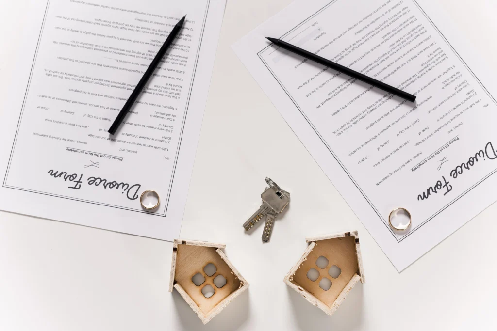 Contrat de location avec clés et maisons miniatures, symbolisant un accord immobilier.
