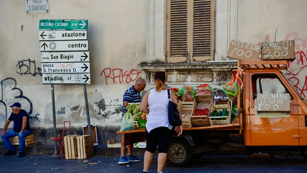 Scène de marché local en Sicile, illustration concrète de la fiscalité en Italie