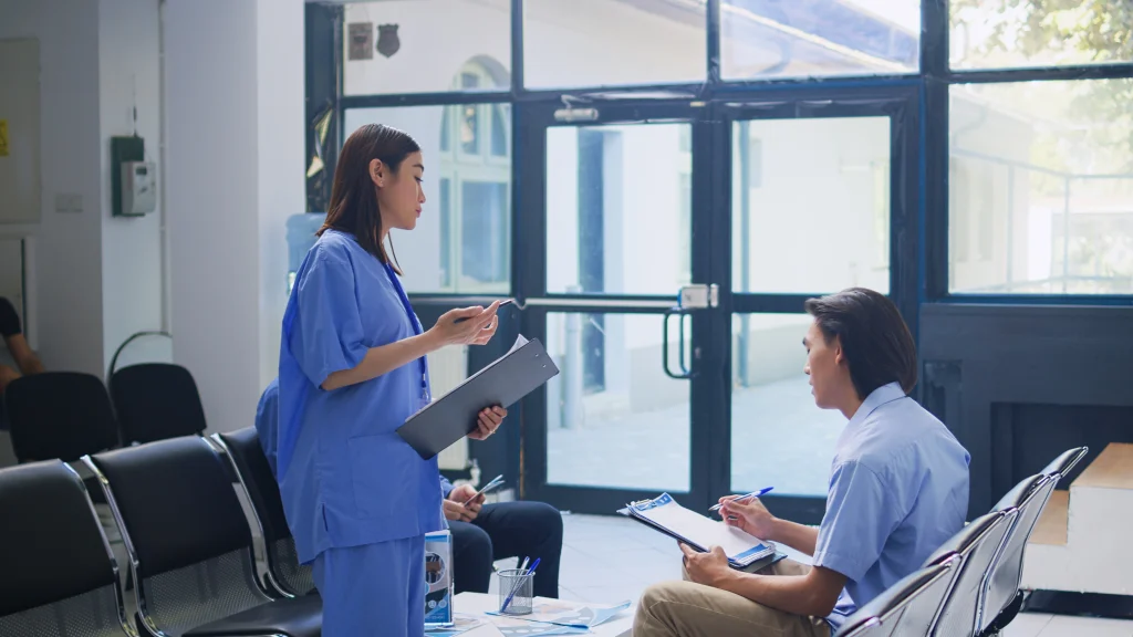 Young Vietnamese patient consulting a nurse in a private clinic, highlighting affordable healthcare as part of the cost of living in Vietnam.