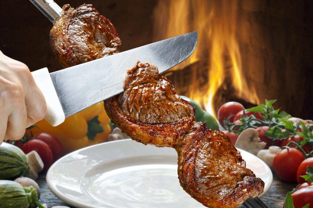 Brazilian churrasco with grilled meat served on skewers, a typical culinary specialty of churrascarias and a must-try of Brazilian cuisine.