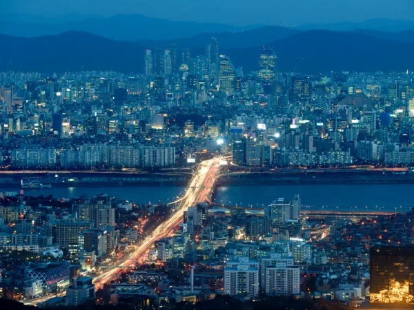 Vue nocturne de Séoul, capitale de la Corée du Sud, avec ses immeubles modernes et ses quartiers résidentiels le long du fleuve Han.