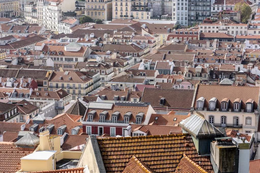 Vue aérienne de toits en tuiles serrés dans un centre-ville européen, illustrant la densité urbaine du logement au Luxembourg.