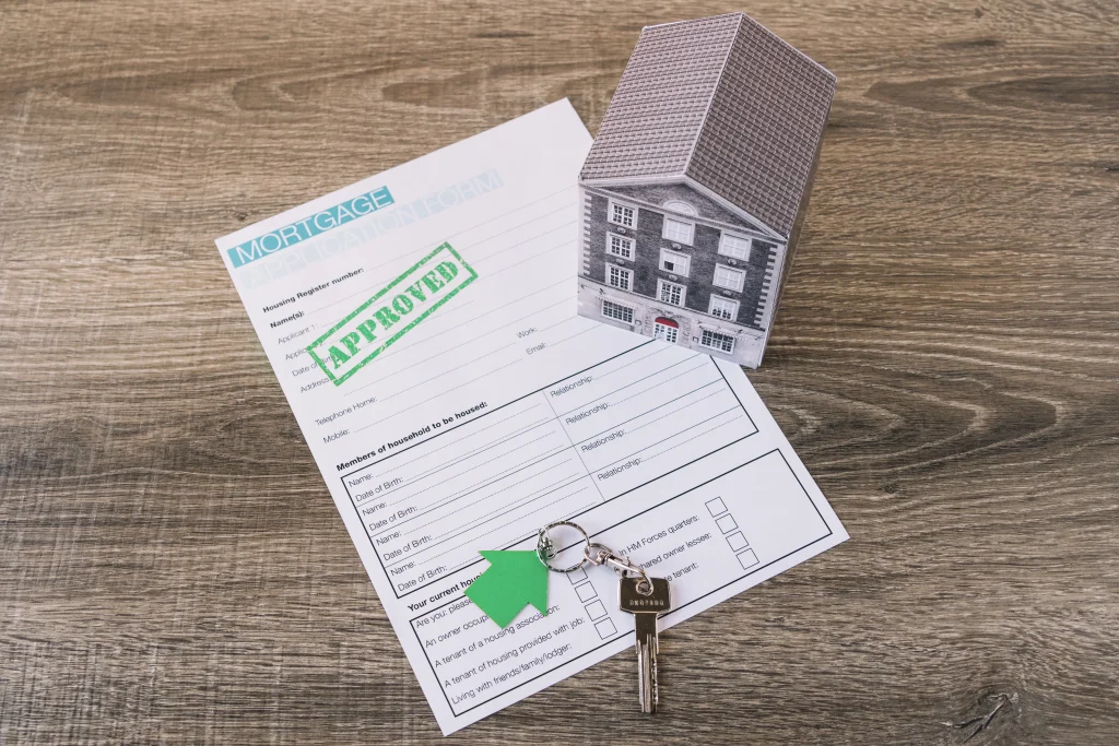 “Approved” mortgage application form with a house model and keys, symbolizing housing in Dubai.