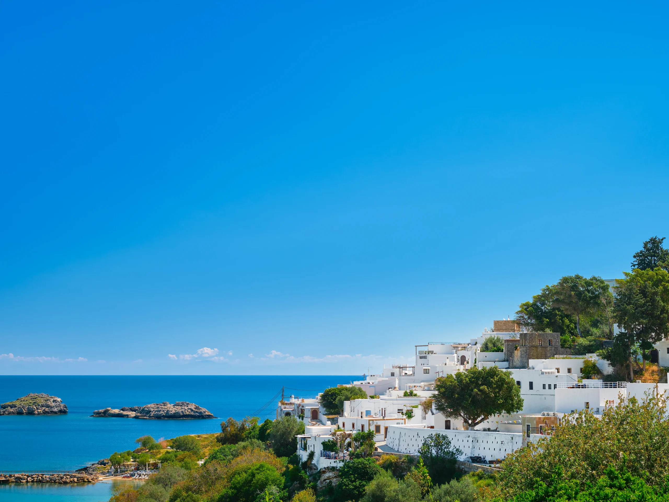 Greek coastal landscape with white houses facing the Aegean Sea, an ideal living environment for studying in Greece.